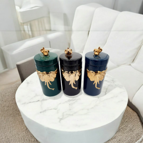 three candy jars with gold elephant engraved placed on a table